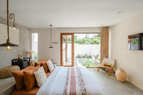 Un dormitorio con una cama grande y una ventana grande. en Canna Uluwatu - Stylish Private 1BR Pool Suite, en Uluwatu