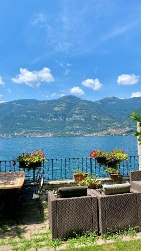 a table and chairs with a view of the water at B&B Nest on the Lake in Lezzeno