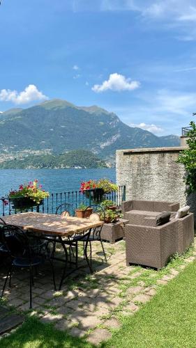a patio with a table and chairs next to the water at B&B Nest on the Lake in Lezzeno