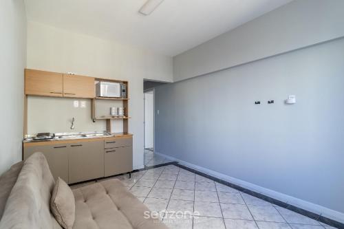 フロリアノポリスにあるEJO - Apartamentos Modernos no Centro de Floripaのソファとキッチンのあるリビングルーム
