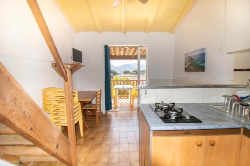 - une cuisine et une salle à manger avec une table et une cuisinière dans l'établissement Le Dui, à Appietto