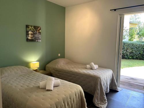 - une chambre avec 2 lits et une porte coulissante en verre dans l'établissement t3cj n14, à Pinarellu