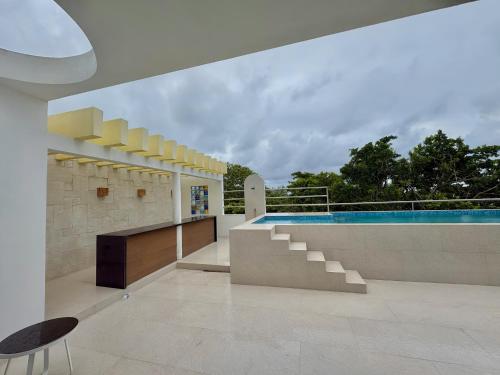 a house with a swimming pool and a patio at Hotel Piedra del Caribe Puerto Morelos in Puerto Morelos