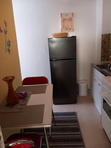 a black refrigerator in a kitchen with a table and chairs at Altstadt Oase Bernkastel-kues in Bernkastel-Kues