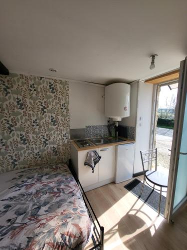 - une petite cuisine avec un lit dans une chambre dans l'établissement Studio Equipé La Glacerie, à Cherbourg en Cotentin