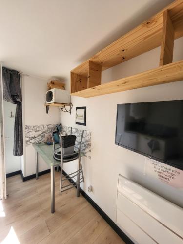 Cette chambre dispose d'un bureau et d'une télévision à écran plat. dans l'établissement Studio Equipé La Glacerie, à Cherbourg en Cotentin