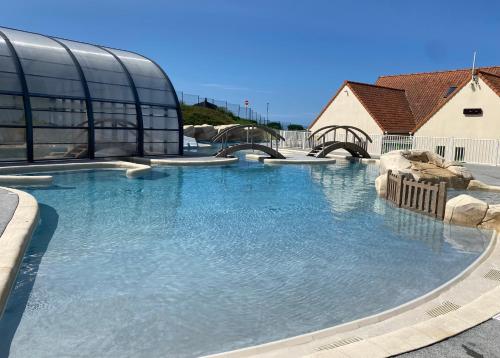 une grande piscine d'eau devant un bâtiment dans l'établissement camping de la falaise à equihen plage, à Équihen-Plage