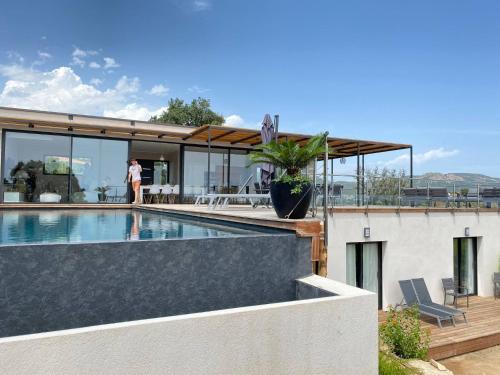 une personne debout sur le toit d'une maison avec piscine dans l'établissement Rostalana, à Pinarellu