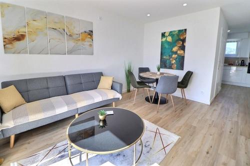 a living room with a couch and a table at Appartement Moderne et Cosy avec Balcon - Parking Gratuit - Netflix in Logelbach