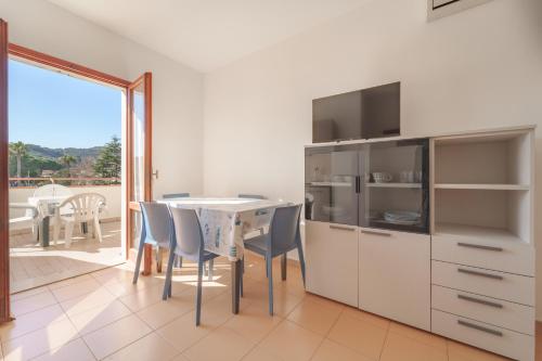 a kitchen with a table and chairs and a balcony at Appartamenti Gli Orizzonti - Goelba in Marina di Campo