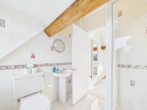 a white bathroom with a toilet and a sink at Romantic Cottage Cotswolds Parking Wi-Fi in Winchcombe