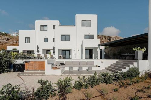 una casa bianca con molti mobili davanti di Villa Elysée, 4 bedroom villa a Naxos Chora