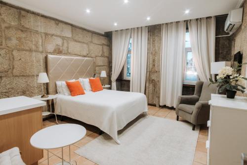 a hotel room with a bed and a chair at Turra Residence in Porto