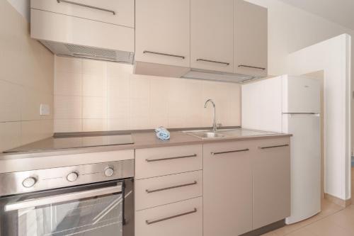 a kitchen with white cabinets and a sink at Appartamenti Gli Orizzonti - Goelba in Marina di Campo