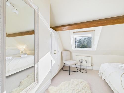 a mirror in a bedroom with a bed and a chair at Romantic Cottage Cotswolds Parking Wi-Fi in Winchcombe