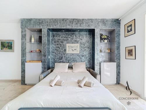 une chambre avec un grand lit blanc avec deux oreillers dans l'établissement Alexandra - 4 pers 61m2 - climatisé - Aperçu Mer, à Cannes