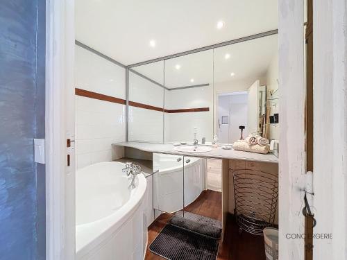 une salle de bain blanche avec une baignoire et un lavabo dans l'établissement Alexandra - 4 pers 61m2 - climatisé - Aperçu Mer, à Cannes