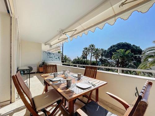 une salle à manger avec une table et des chaises sur un balcon dans l'établissement Alexandra - 4 pers 61m2 - climatisé - Aperçu Mer, à Cannes