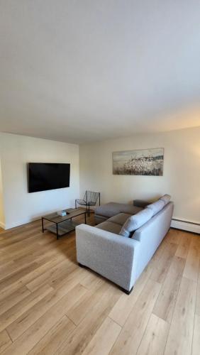 a living room with a couch and a flat screen tv at ENTIRE 2 BEDROOM APARTMENT by UW RESEARCH PARK - PS5 in Waterloo
