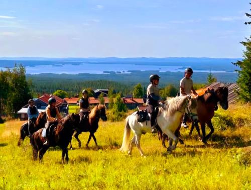a group of people riding horses in a field at Utsikten in Borlänge
