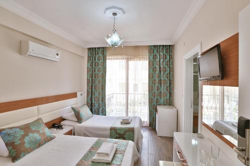 a hotel room with a bed and a tv at Hotel Kayahan in Kas