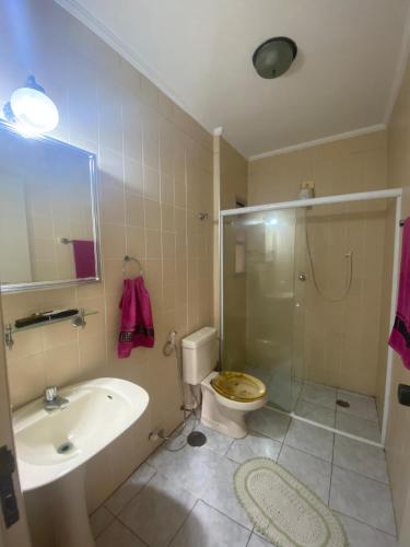 a bathroom with a toilet and a sink and a shower at Enseada Malibu perto da praia, lazer e conforto! in Guarujá