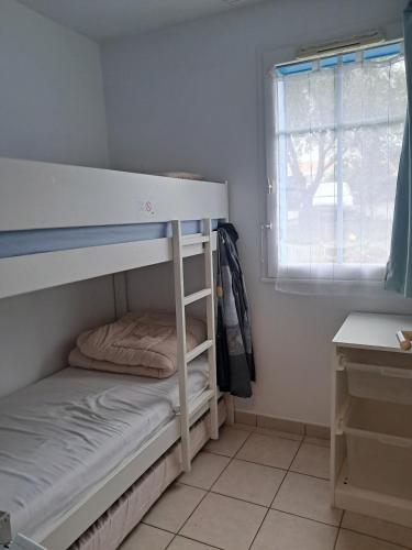une chambre avec un lit superposé et une fenêtre dans l'établissement Bel Appart 6 pers, terrasse, vue Golf Port Bourgenay, à Talmont-Saint-Hilaire