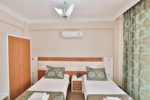 a hotel room with two beds and a window at Hotel Kayahan in Kas