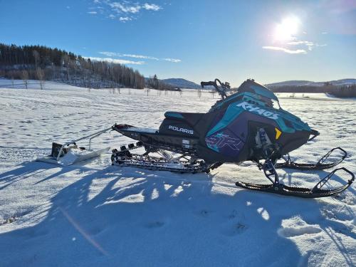 a snowmobile parked in the snow on a field at Utsikten in Borlänge