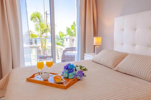 a hotel room with a bed with two glasses of orange juice at Madeira Beach House by Atlantic Holiday in Madalena do Mar