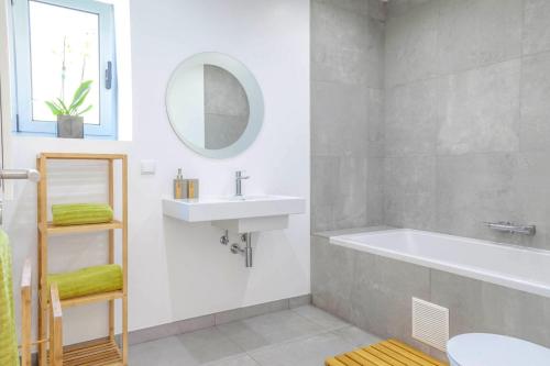 a bathroom with a sink and a tub and a mirror at Madeira Beach House by Atlantic Holiday in Madalena do Mar