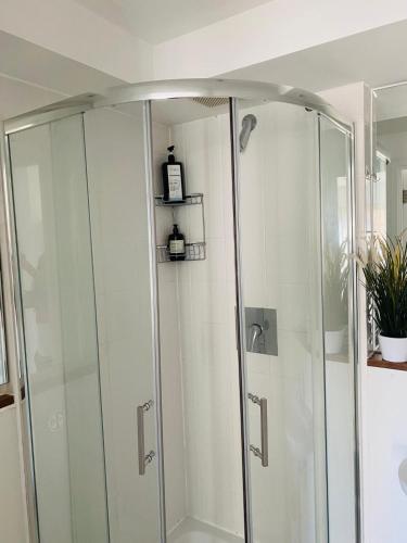 a shower with glass doors in a bathroom at North Greenwhich Homestay in London