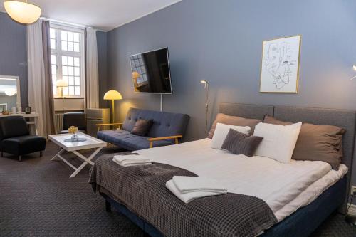 a bedroom with a large bed and a living room at Furunäset Hotell & Konferens in Piteå