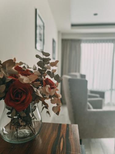 a vase filled with red roses sitting on a table at La Urumpta Hotel, AKEN MIND in Río Cuarto