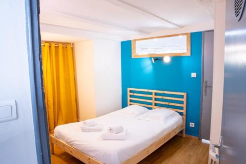 - un petit lit dans une chambre dotée d'un mur bleu dans l'établissement Cosy Tournusien By Primo Conciergerie, à Tournus