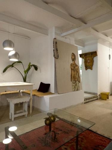 Zimmer mit einer Statue und einem Glastisch in der Unterkunft La maison de oiseaux in Salambôo