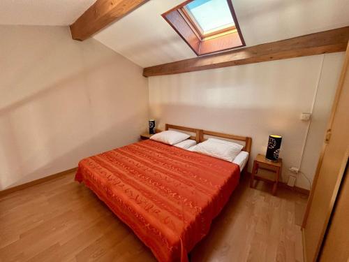 - une chambre avec un lit rouge et une lucarne dans l'établissement Appartement T3 avec mezzanine et parking au Rayol-Canadel - FR-1-226B-176, à Rayol-Canadel-sur-Mer