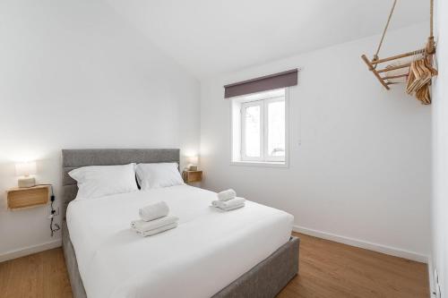 a bedroom with a white bed with towels on it at GuestReady - Oporto Old Town House 3 in Porto