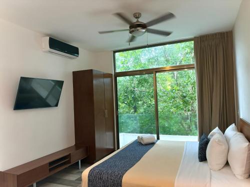 a bedroom with a bed and a large window at Hotel Piedra del Caribe Puerto Morelos in Puerto Morelos