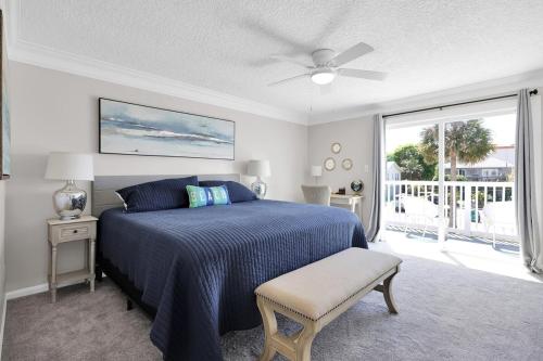Un dormitorio con una cama y un ventilador de techo. en Steps to the Beach from this Salt Air Home, en Jacksonville Beach