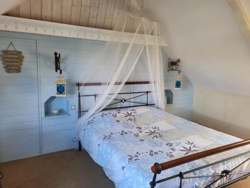 a bedroom with a bed with a canopy at Clos St Ange (Dinan-St Malo) in Vildé-Guingalan