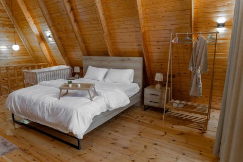 a bedroom with a bed in a wooden cabin at شاليهات اكواخ كايا الفندقية in Khalij Salman