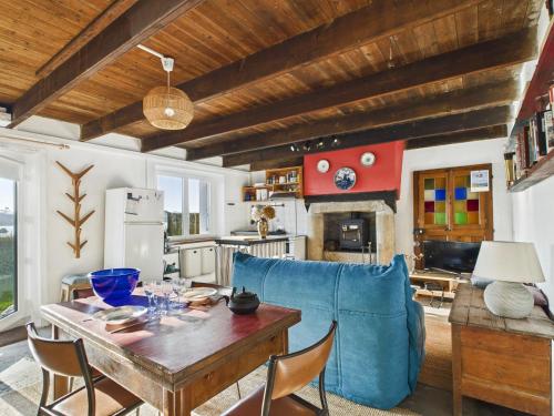 un salon avec une table et un canapé bleu dans l'établissement Maison vue mer pour 2 à Plouguerneau, à Plouguerneau
