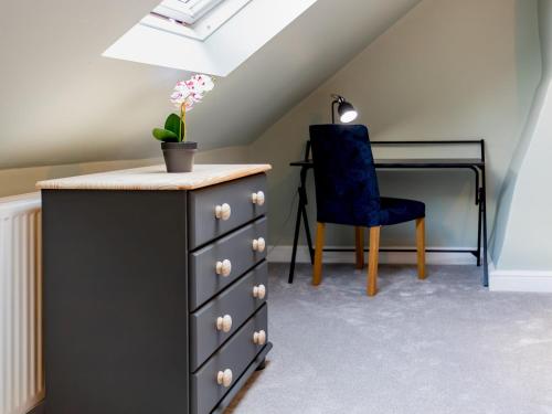 a bedroom with a dresser and a blue chair at Pass the Keys Stylish 2 Bed Flat near Beach M5 in Burnham on Sea