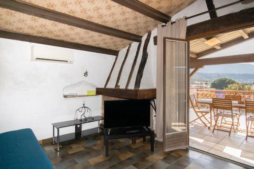Il comprend un salon avec une télévision et un balcon avec une table. dans l'établissement Le Figuera, à Appietto