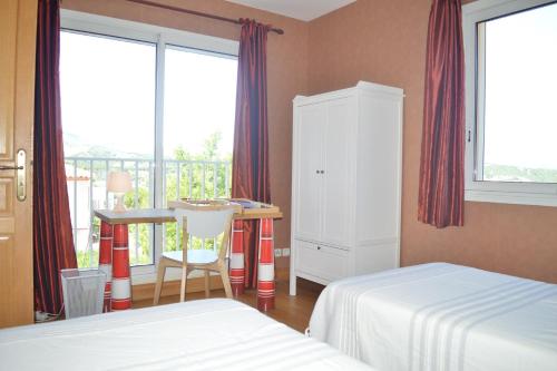 une chambre avec deux lits et un bureau et une fenêtre dans l'établissement Appart 3 pièces 4 couchages BANYULS SUR MER BN000-09B, à Banyuls-sur-Mer