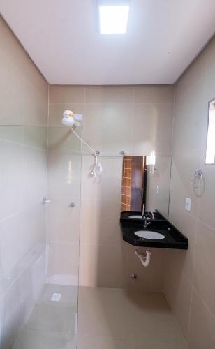 a bathroom with a shower and a sink at Pousada Calugy in Jardim