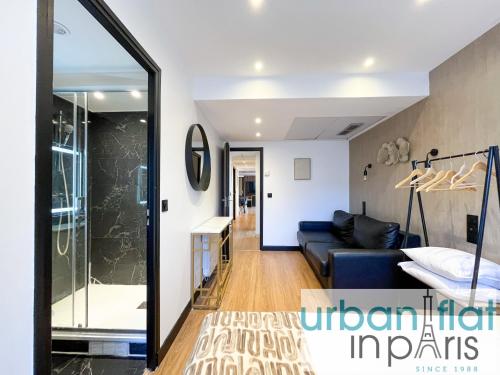 - un salon avec un canapé et une porte en verre dans l'établissement Urban Flat 128 - Art Rock 4BDR Flat near Champs-Elysees, à Paris
