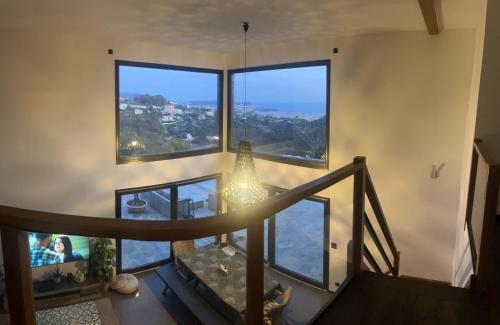 Cette chambre est dotée d'un escalier et de grandes fenêtres. dans l'établissement Villa location saisonniere, à Nice