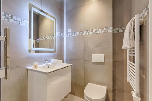 une salle de bain avec toilettes, lavabo et miroir dans l'établissement TBS 307 - Superb studio in the heart of Paris, à Paris